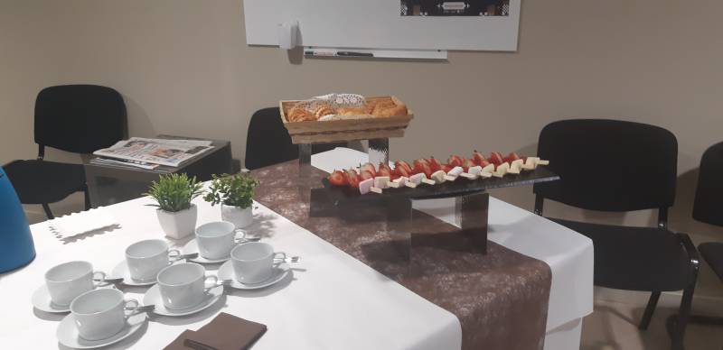 Préparation de café d’accueil pour réunion de travail avec nappage et serviettes